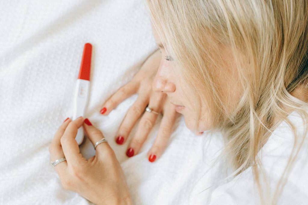 Frau schaut auf einen Schwangerschaftstest